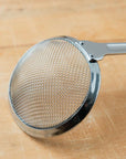 Metal strainer on a wooden surface