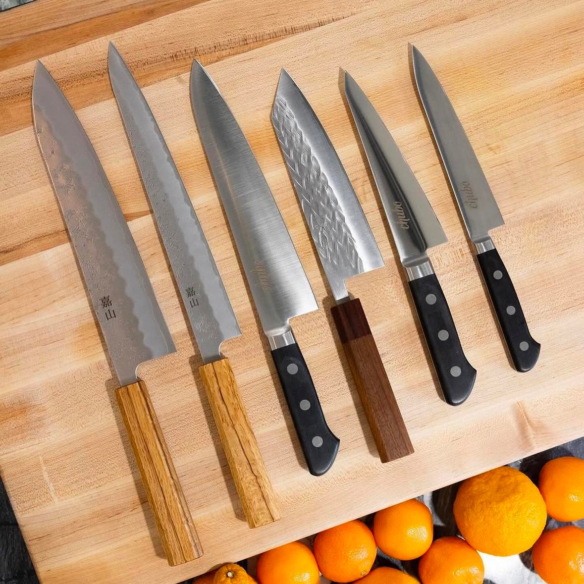 A selection of Chubo Knives on a wood cutting board