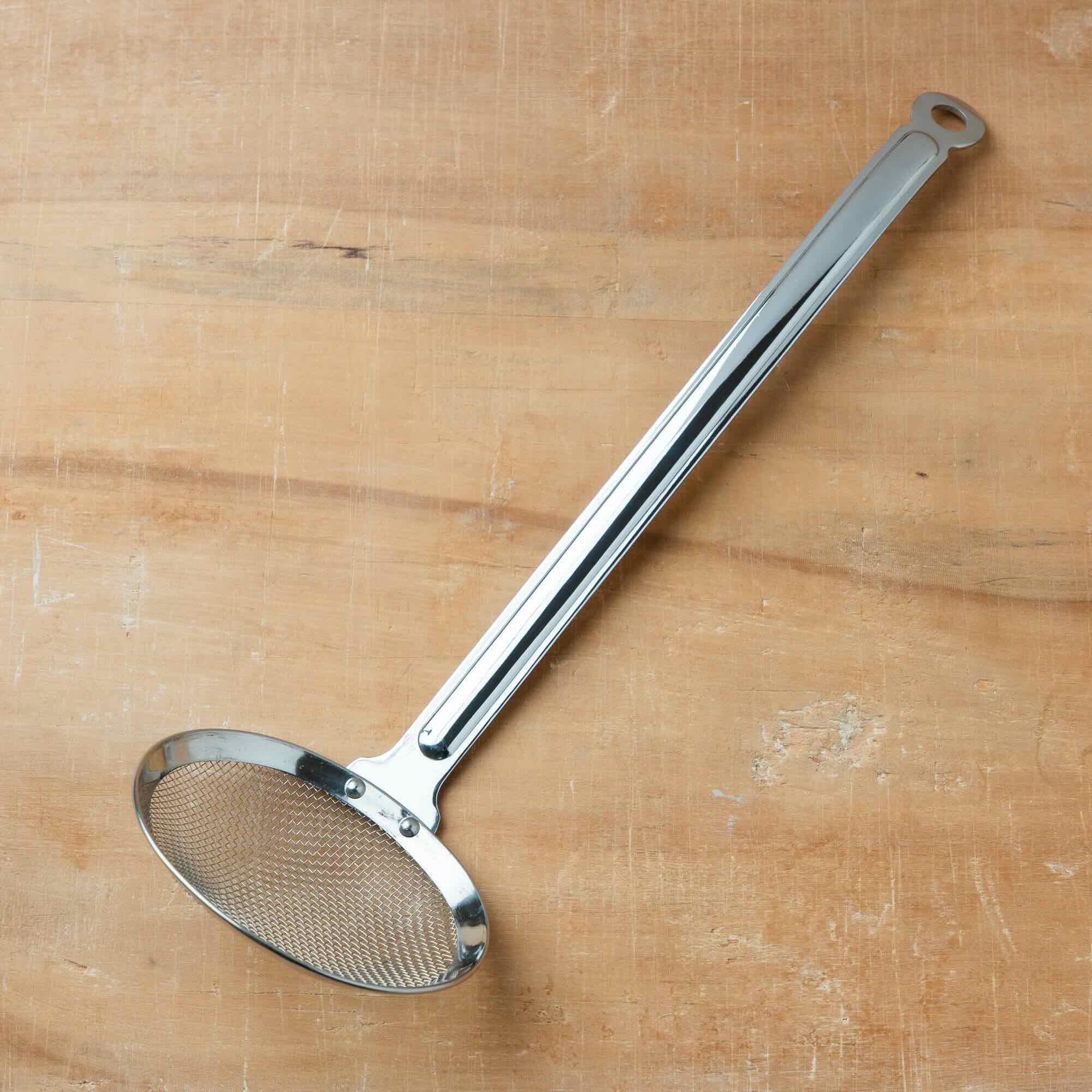 Metallic ladle on a wooden surface