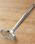 Metallic ladle on a wooden surface