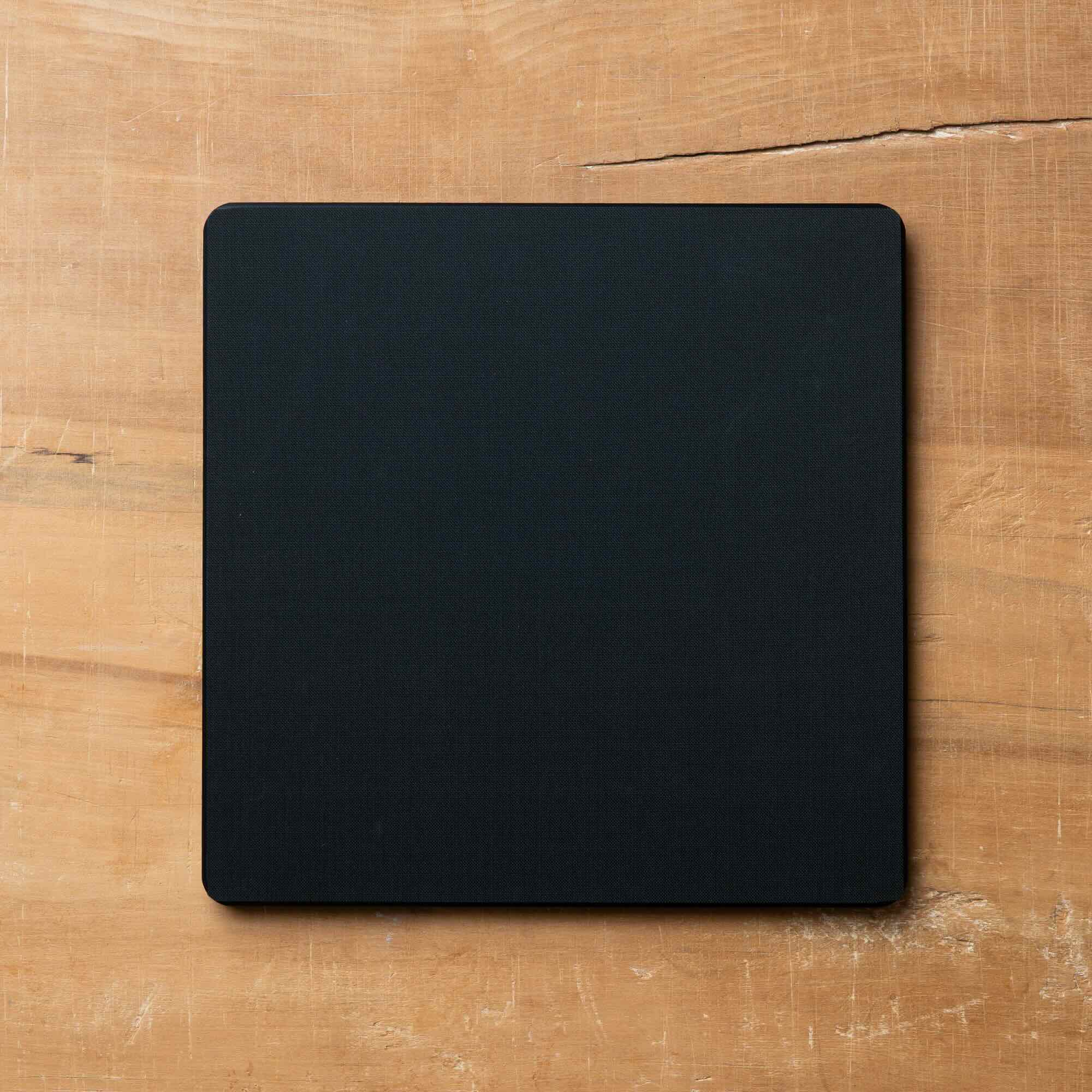 Black square cutting board on a wooden surface