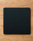 Black square cutting board on a wooden surface
