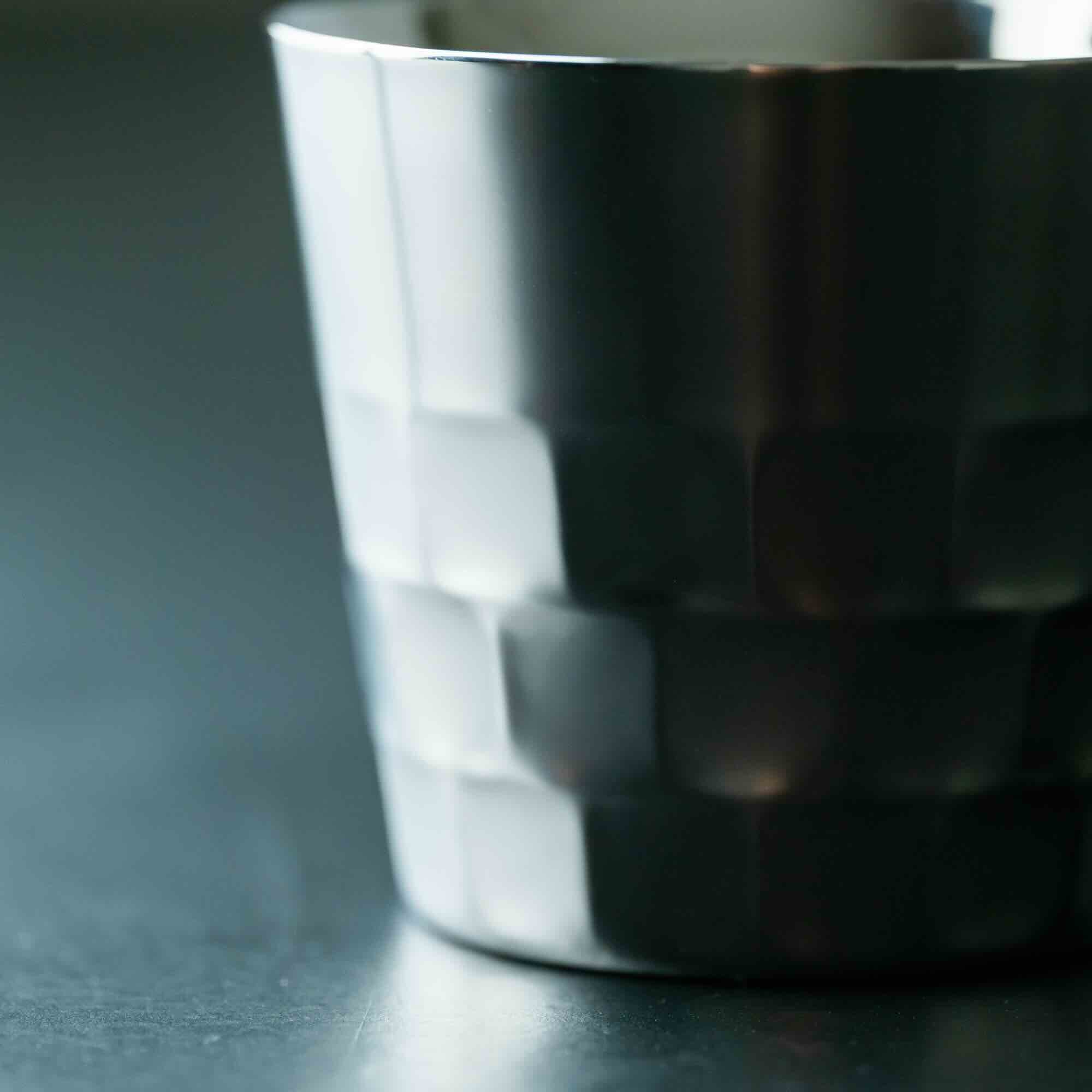 Shiny metallic cup on a dark surface