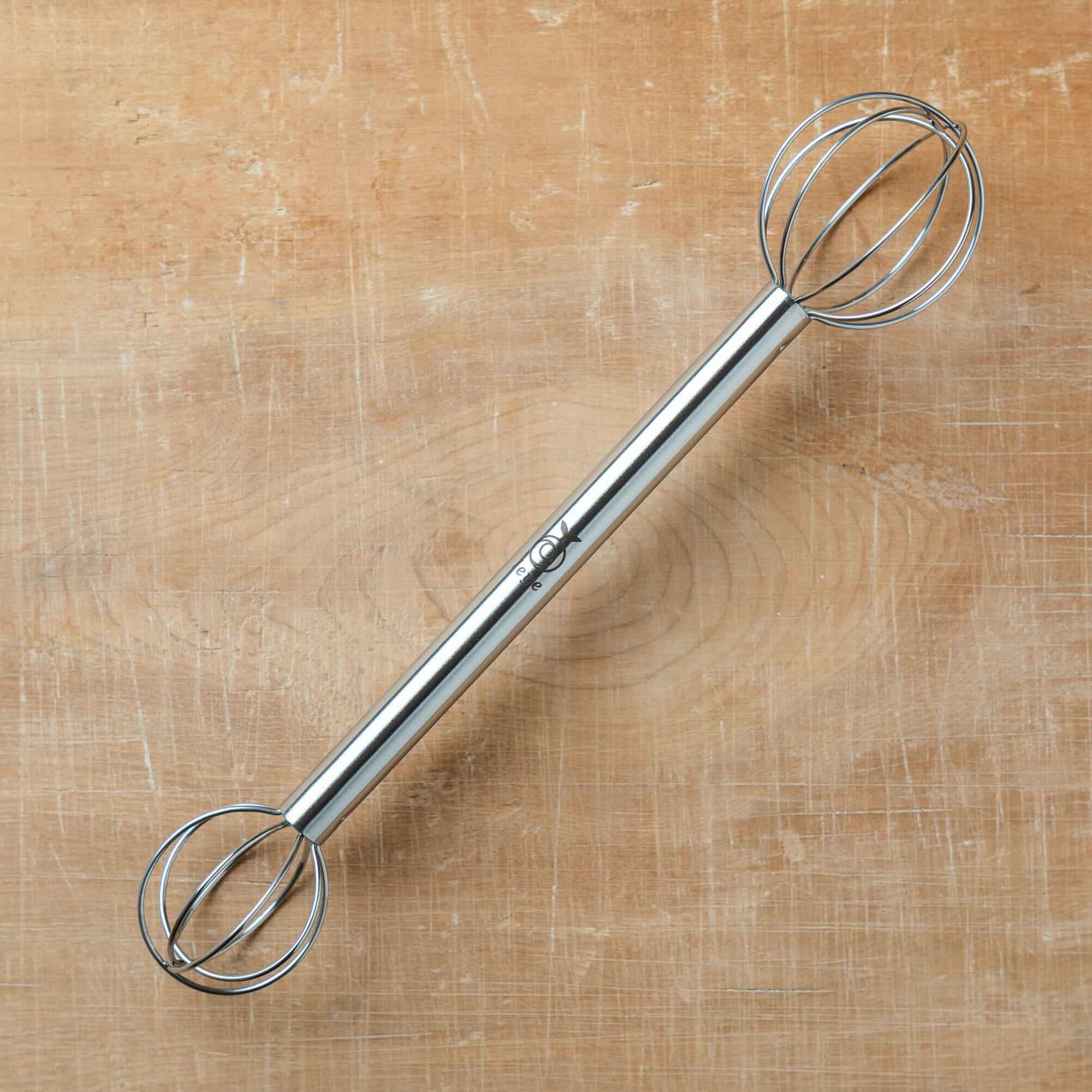 Metal miso whisk on a wooden surface