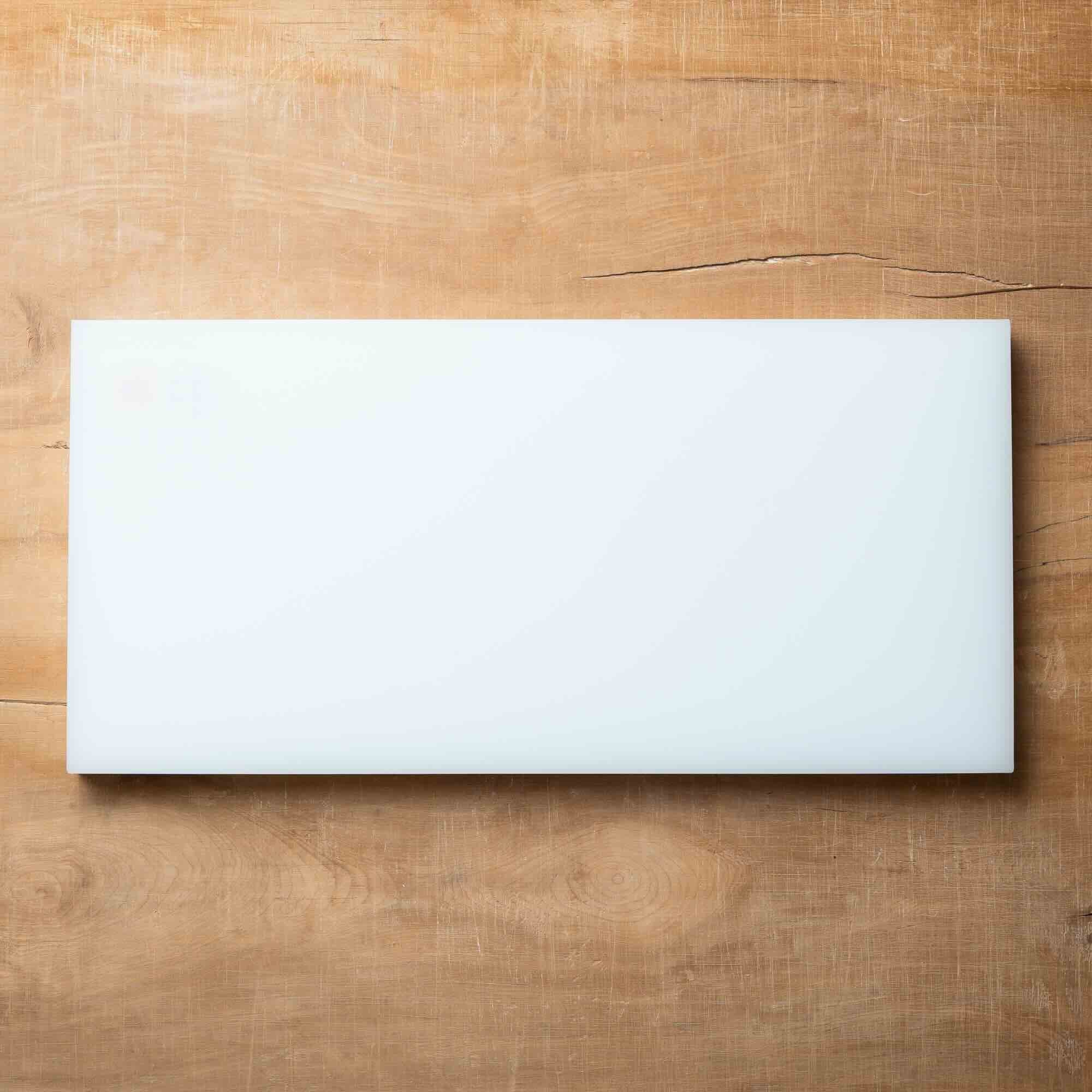 White rectangular cutting board on a wooden surface