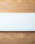 White rectangular cutting board on a wooden surface